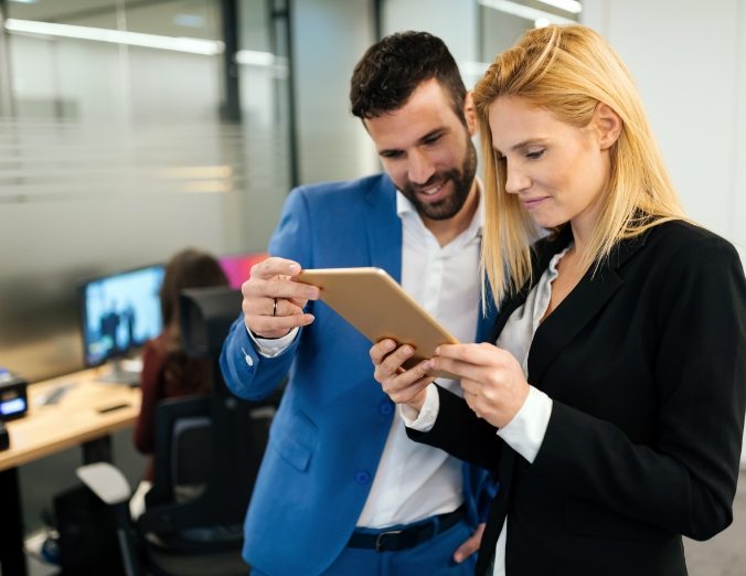 businesspeople-discussing-while-using-digital-WFGVC3X@2x